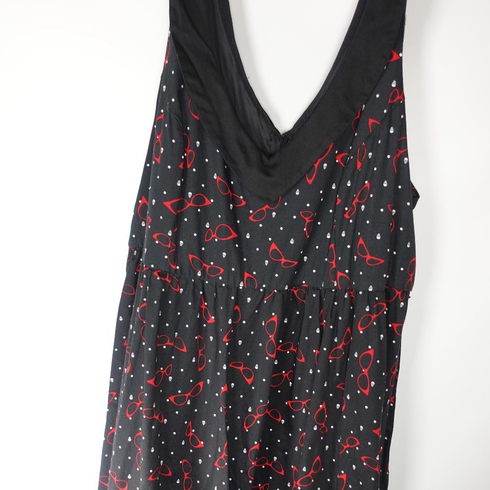 Black Sleeveless Retro Chic 'Swing' Dress with cat-eye glasses & skulls.